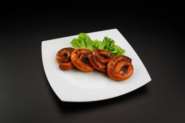 Beyaz tabakta ızgara sosis.