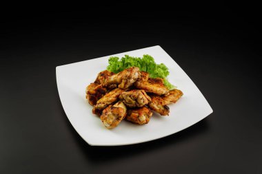 Beyaz tabakta ızgara tavuk kanadı..