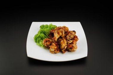 Beyaz tabakta ızgara tavuk kanadı..