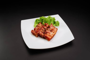 Beyaz tabakta ızgara domuz pastırması.