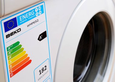 Bir çamaşır makinesinde Avrupa Birliği Enerji Tüketim Etiketi. AB 'de satılan bütün beyaz malların enerji tüketimi, verimliliği ve ürünün gürültü seviyeleri hakkında veri sağlayan bir Enerji Derecelendirme etiketine sahip olması gerekir.