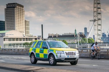 LONDON, ENGLAND - 27 Mayıs 2020: COVID-19 salgını sırasında arka planda London Eye ile Waterloo köprüsündeki bir Londra ambulansının yakın görüntüsü
