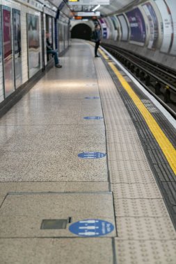 LONDON, ENGLAND - 8 Haziran 2020: 3 sosyal mesafeli alan gereksinimlerini tavsiye eden Londra Yeraltı Platformunu imzalayın