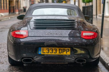 LONDON, ENGLAND - 10 Haziran 2020: COVID-19 salgını sırasında Holborn, Londra, İngiltere 'de sağanak yağmur damlalarıyla kaplı Porsche Carrera supercar
