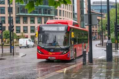 LONDON, ENGLAND - 10 Haziran 2020: COVID-19 salgını sırasında Londra 'nın Holborn kenti boyunca yağmurda giden modern çevre dostu tek katlı kırmızı Londra otobüsü