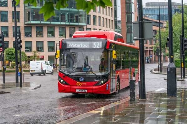 LONDON, ENGLAND - 10 Haziran 2020: COVID-19 salgını sırasında Londra 'nın Holborn kenti boyunca yağmurda giden modern çevre dostu tek katlı kırmızı Londra otobüsü