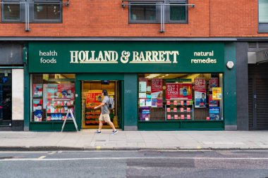 Londra, Holborn, Londra 'da 24 Temmuz 2020' de COVID-19 salgını sırasında yüzünde maske olan bir adamla birlikte Hollanda & Barrett Sağlıklı Gıda Dükkanı