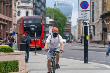 Londra - 3 Haziran 2020: Holborn London 'da bisiklet süren yaşlı erkek bisikletçi yüz maskesi, gözlük ve kask takarak COVID-19 salgını sırasında göz teması kuruyor - 003