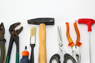 Beyaz arkaplanda izole edilmiş pense, makas ve tornavida gibi farklı araçlar