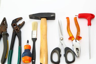 Beyaz arkaplanda izole edilmiş pense, makas ve tornavida gibi farklı araçlar