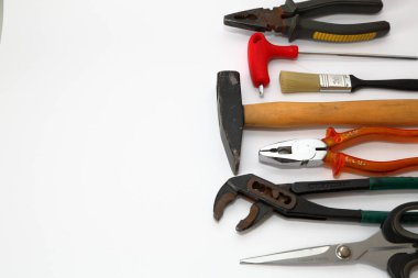 Beyaz arkaplanda izole edilmiş pense, makas ve tornavida gibi farklı araçlar