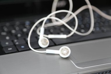 Dizüstü bilgisayardaki akıllı telefon kulaklıkları.