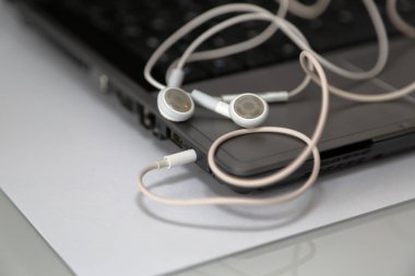 Dizüstü bilgisayardaki akıllı telefon kulaklıkları.