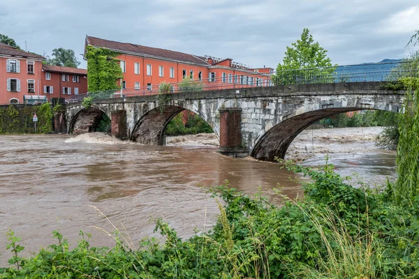 swollen river after a storm with the waters touching the bridge