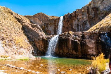 Peru, Marcapomacocha 'da nefes kesen iki katlı bir şelale kayalıklar ve altın And çayırlarıyla çevrili açık bir zümrüt havuzuna düşer. Çevre turizmi ve seyahat için mükemmel bir doğa harikası..