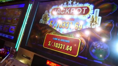 Lima, Peru, 29 Nisan 2023: Bir slot makinesi ekranının yakın çekim videosu altın sikkeler ve parlayan ışıklarla büyük ikramiye kazanan bir mesajı gösteriyor. Kumar, kumarhane eğlencesi, şans, bahis, para kazanmak ve gece hayatı için idealdir..