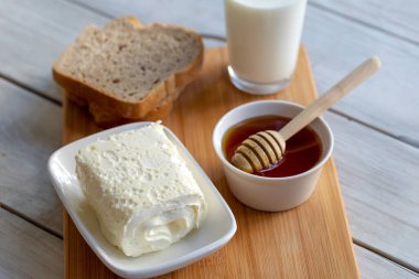 Türk kahvaltısı / Kaymak için pıhtılaşmış krema (tereyağı kreması), bal ve bir bardak süt
