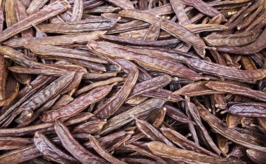 Markette keçiboynuzu podları, arka plan