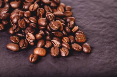 Kahve çekirdekleri koyu taş masada..