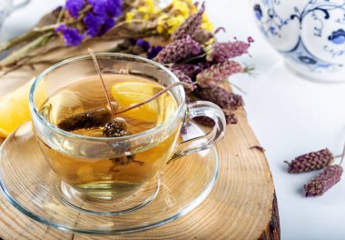 Bir fincan Lavandula Stoechas çayı (lavanta çayı) ve beyaz arka planda limon..