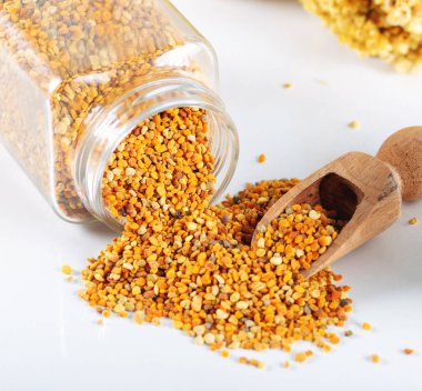 Beyaz arkaplanda arı poleni taneleri.