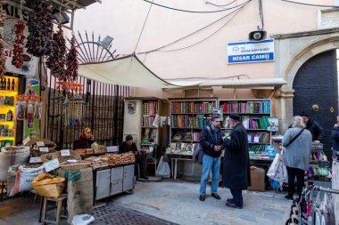Kemeralti, Konak, İzmir / Türkiye - 02 / 07 / 2019: İnsanlar dar sokaklardan alışveriş yapıyor ve küçük kafelerde dinleniyor. İnsanlar dar sokaklardan alışveriş yapıp küçük kafelerde dinleniyorlar. Hisar Camii 'nin etrafındaki sokaklara bak..