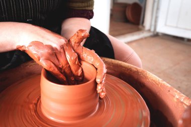 Professional potter making bowl in pottery workshop clipart