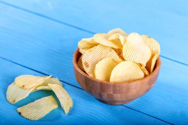 Tahta arka planda tahta kasede patates cipsi..