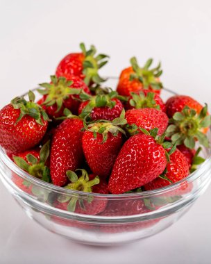 Cam kasede taze çilek ve ahşap zeminde bir bardak çilekli süt.