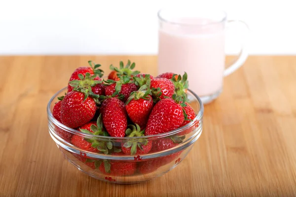 Cam kasede taze çilek ve bir bardak çilekli süt.