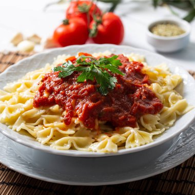 Ahşap masada domates soslu makarna.