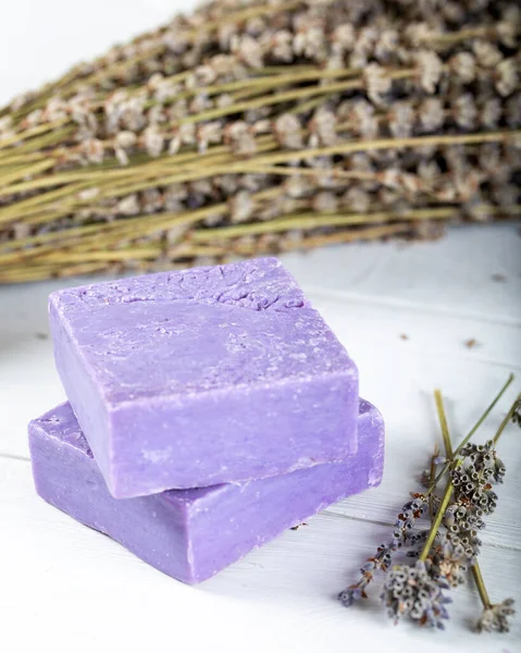Lavender soap with dried lavender on wooden background.