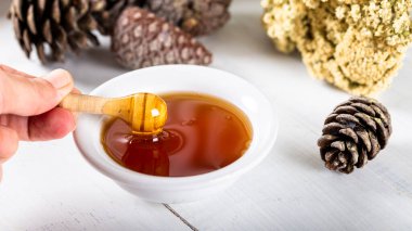 Çam ağacı, doğal çam balı ahşap arka planda kasede..