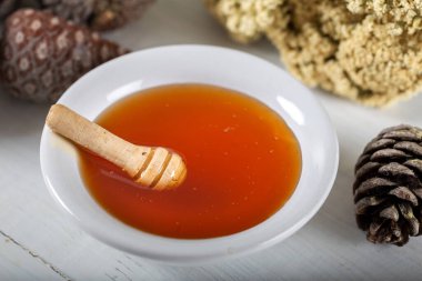 Çam ağacı, doğal çam balı ahşap arka planda kasede..