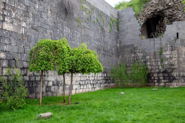 Old City Walls in the city of Diyarbakir, Turkey. People walk around the city walls and rest.