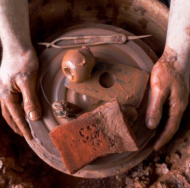 Kil tencereli bir çömlekçinin elleri