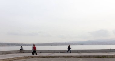 Karsiyaka, İzmir / Türkiye - 02 / 09 / 2018: Kıyı parkında dinlenen ve sohbet eden insanlar, Karsiyaka, Türkiye.