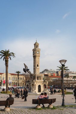 Konak, İzmir - Türkiye: 02-23-2018: İzmir Saat Kulesi (1901 yılında inşa edildi) İzmir 'in Konak Meydanı' nda bulunan tarihi saat kulesidir. İnsanlar Konak Meydanı 'nda vakit geçiriyor.