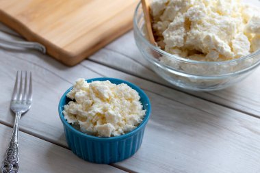 Ahşap arka planda bir kasede peynir.