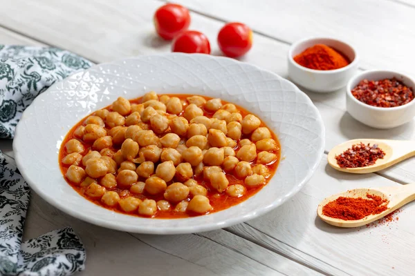 Ahşap zemin üzerinde vejetaryen baharatlı tavuk bezelye çorbası / Cheakpea yahnisi / Türk nohut pilaki