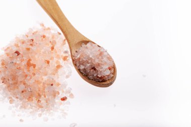 Beyaz arka planda kaşık içinde pembe himalaya tuzu
