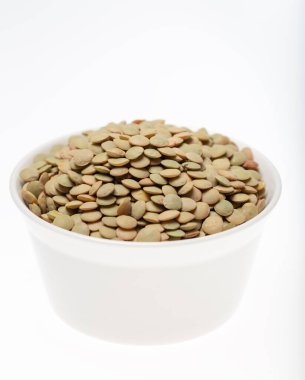 Beyaz arka planda bir kase yeşil mercimek