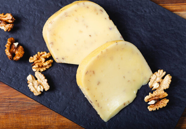 Delicious gouda cheese with walnut on dark stone