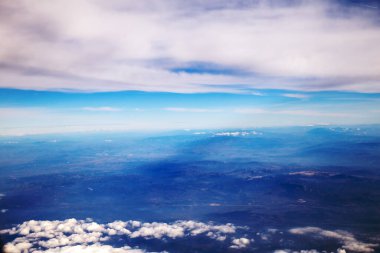 Güzel gökyüzü manzarası ve uçağın penceresinden bulutlar.