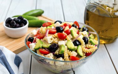 Beyaz arka planda makarna ile Yunan salatası.