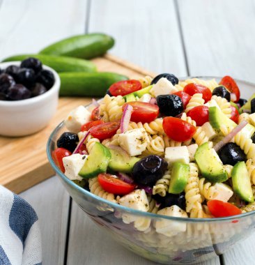 Beyaz arka planda makarna ile Yunan salatası.