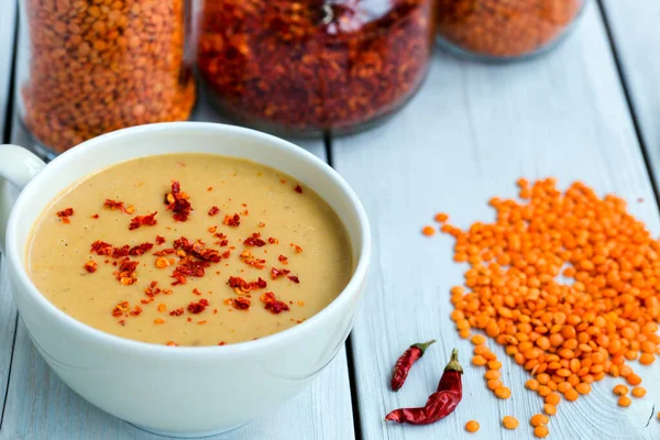Ahşap zemin üzerinde kurutulmuş kırmızı biberli mercimek çorbası.