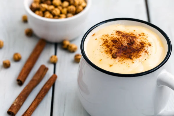 Boza or Bosa with cinnamon and roasted chickpea; Traditional Turkish drink made of millet or corn flour
