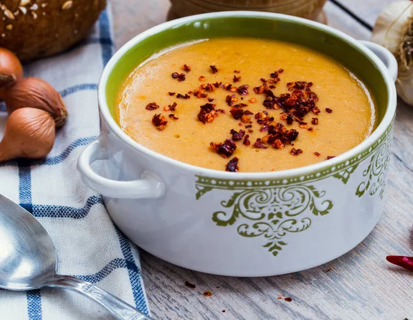 Ahşap arka planda sebzeli kırmızı mercimek çorbası.