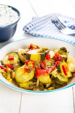 Beyaz arkaplanda buğulanmış yeşil kabak tabağı.